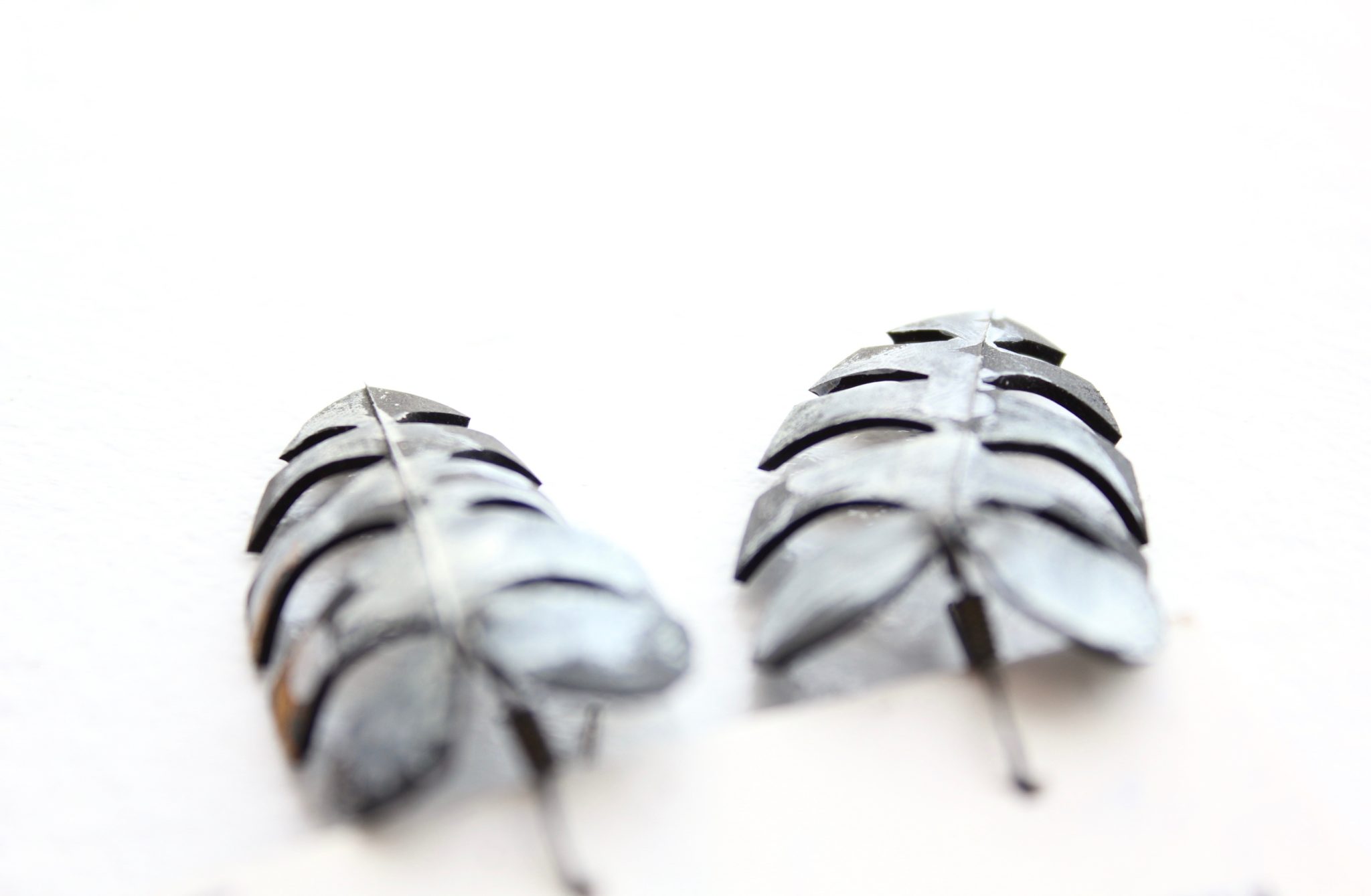 Detail of fern-shaped upcycled bike tube earrings by Tubed Jewellery